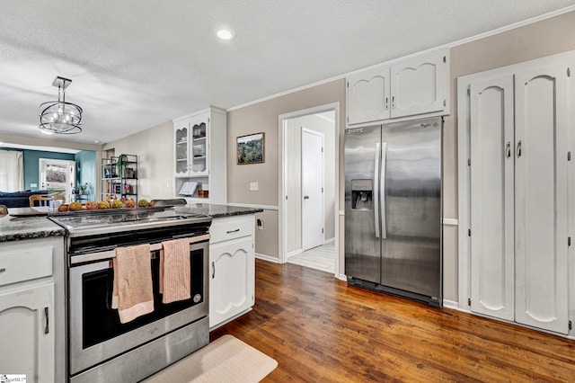 kitchen featuring a textured ceiling, stainless steel appliances, white cabinets, dark wood finished floors, and glass insert cabinets