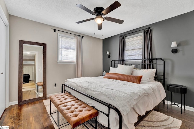 bedroom with ceiling fan, a textured ceiling, baseboards, and wood finished floors