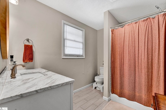 full bathroom with baseboards, toilet, wood finished floors, a textured ceiling, and vanity