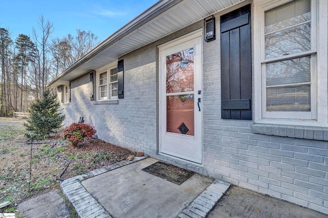 view of exterior entry with brick siding