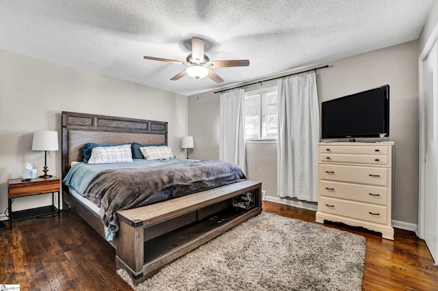 bedroom featuring a textured ceiling, wood finished floors, a ceiling fan, and baseboards