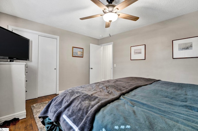 bedroom with a ceiling fan, a closet, a textured ceiling, and wood finished floors