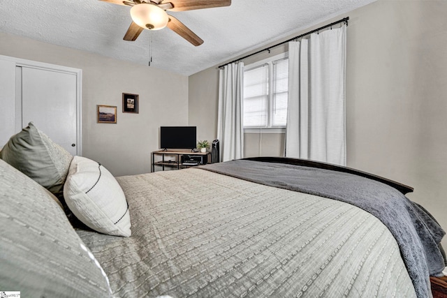 bedroom with ceiling fan and a textured ceiling