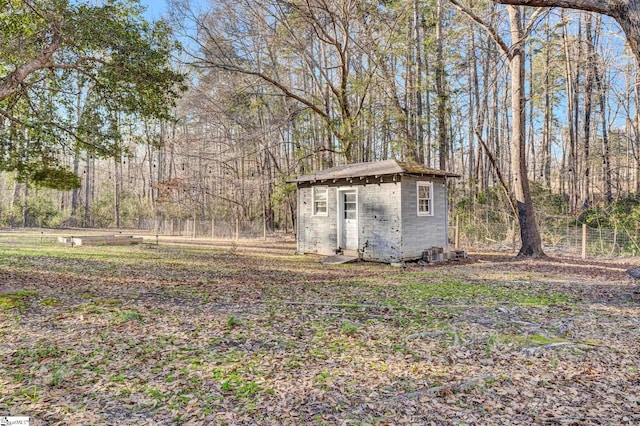 view of yard with an outbuilding, a storage shed, and a wooded view