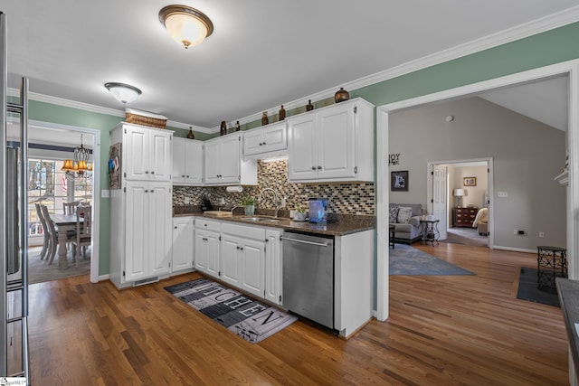 kitchen featuring appliances with stainless steel finishes, white cabinets, a sink, and crown molding