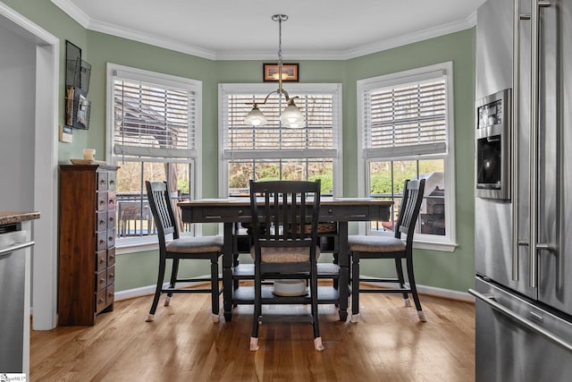 dining room with baseboards, ornamental molding, and wood finished floors