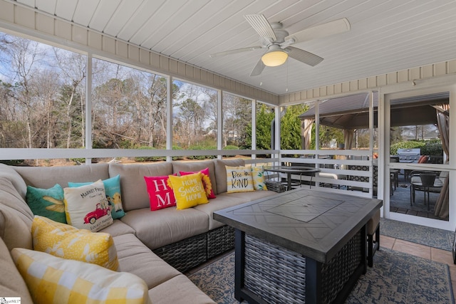 sunroom featuring wood ceiling, a healthy amount of sunlight, and ceiling fan