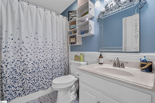 full bath with curtained shower, wainscoting, vanity, and toilet