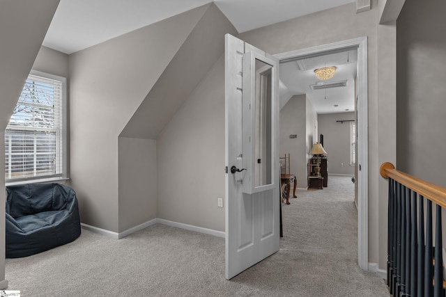 additional living space with carpet floors, attic access, and baseboards