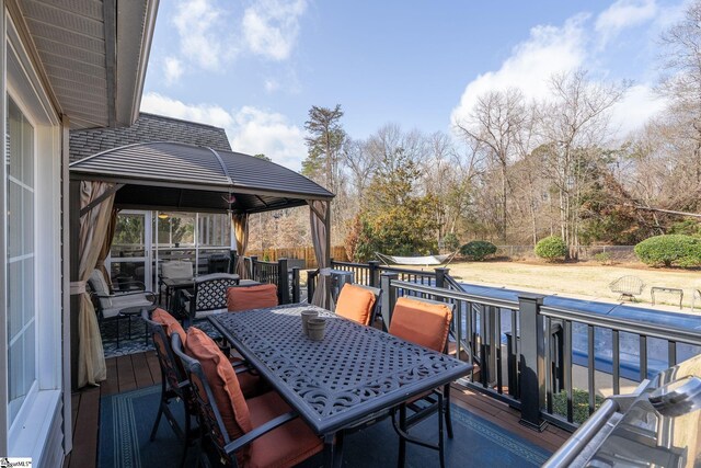 wooden terrace featuring outdoor dining area and fence