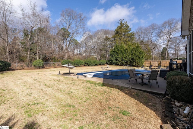 view of swimming pool featuring a diving board, a yard, a patio, and a fenced backyard