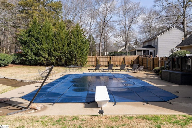 view of swimming pool featuring a diving board, a patio area, fence, and a fenced in pool