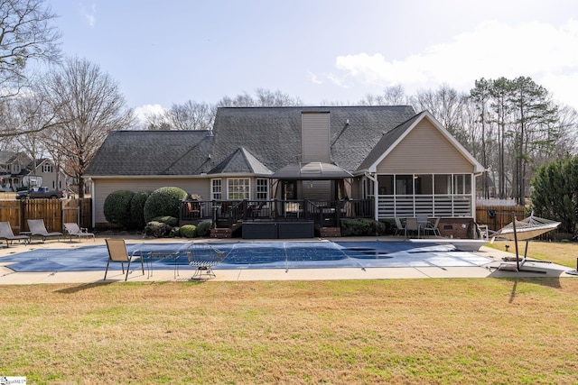 view of pool with a sunroom, fence, a lawn, and a wooden deck