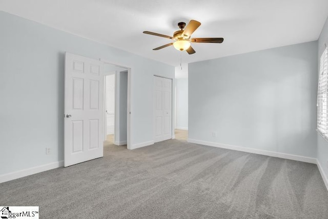 unfurnished bedroom featuring carpet flooring, a ceiling fan, and baseboards