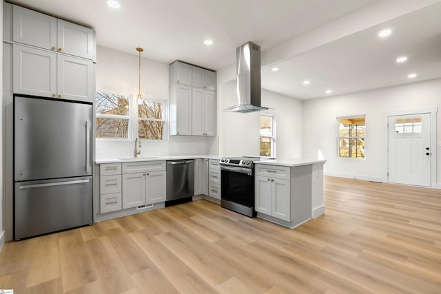 kitchen featuring stainless steel appliances, a peninsula, a wealth of natural light, and range hood