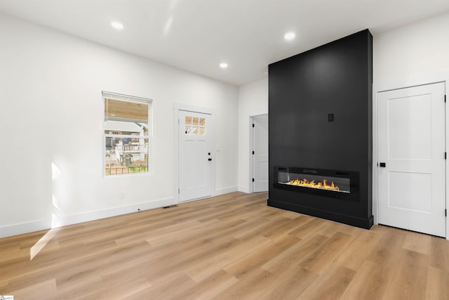 entryway featuring a fireplace, recessed lighting, visible vents, light wood-style flooring, and baseboards