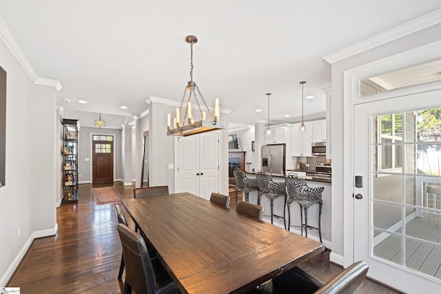 dining area with baseboards, dark wood-style floors, ornamental molding, a notable chandelier, and recessed lighting