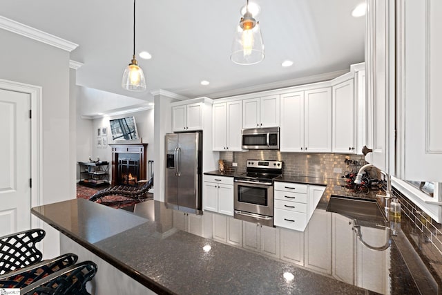 kitchen featuring crown molding, decorative backsplash, stainless steel appliances, and a sink