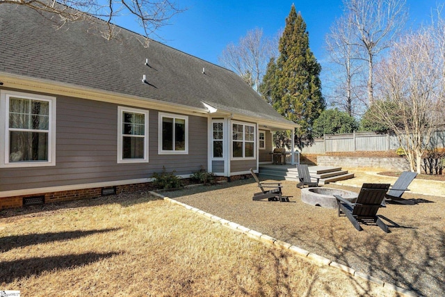 back of house with crawl space, a shingled roof, fence, and a fire pit