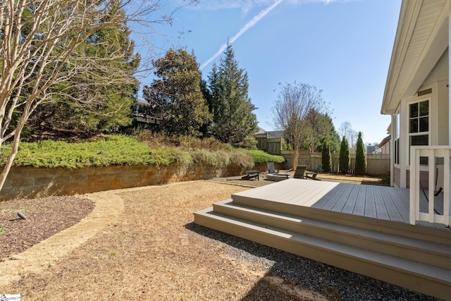 wooden terrace with a fenced backyard and a water view