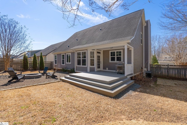 back of property featuring a fenced backyard, a chimney, a fire pit, and a wooden deck