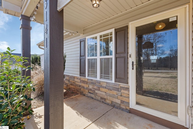 entrance to property with stone siding and covered porch