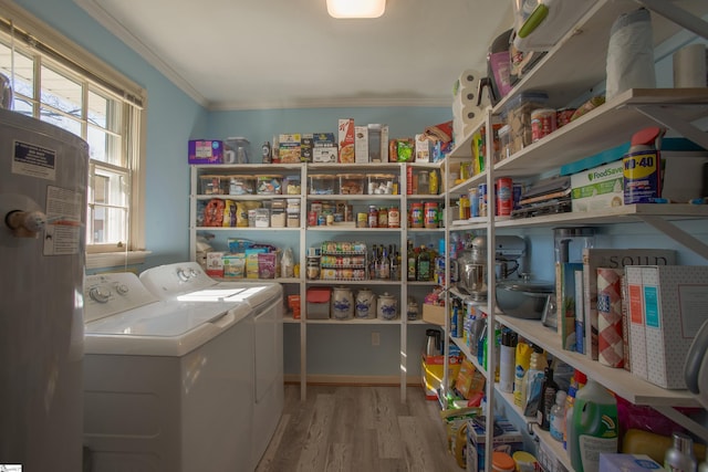 interior space featuring water heater, ornamental molding, separate washer and dryer, wood finished floors, and laundry area