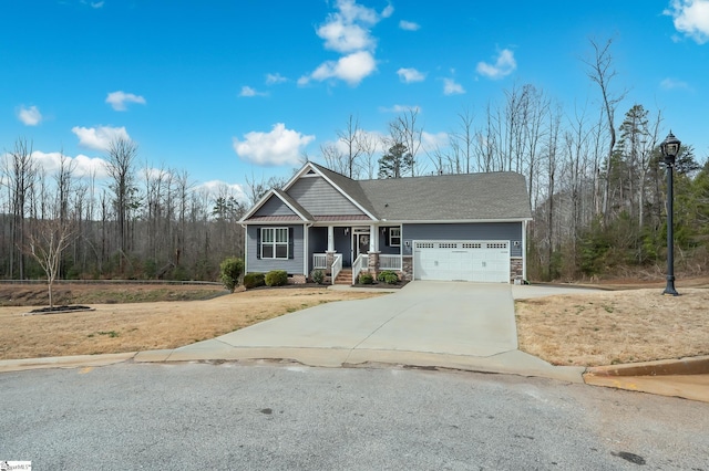 view of front of home with stone siding, concrete driveway, covered porch, and an attached garage