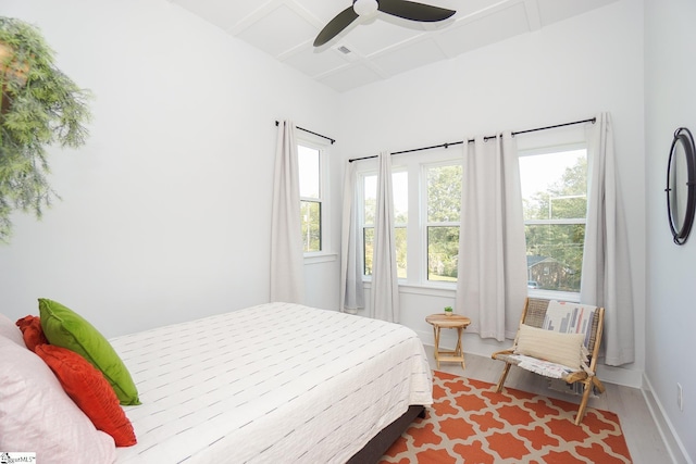 bedroom with coffered ceiling, wood finished floors, a ceiling fan, and baseboards