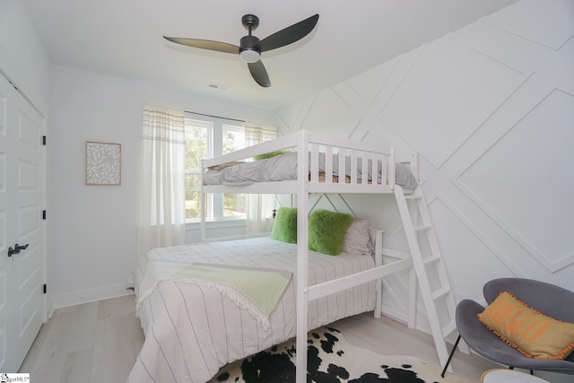 bedroom featuring visible vents, ceiling fan, baseboards, and wood finished floors