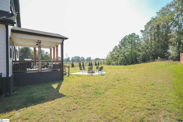 view of yard featuring a patio area, an outdoor fire pit, and a ceiling fan