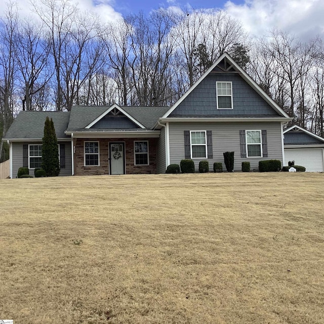 craftsman inspired home with a detached garage, a front lawn, and an outdoor structure