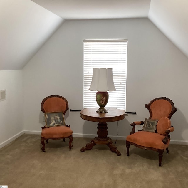 sitting room with carpet floors, vaulted ceiling, and baseboards