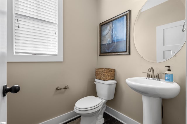 bathroom with toilet and baseboards