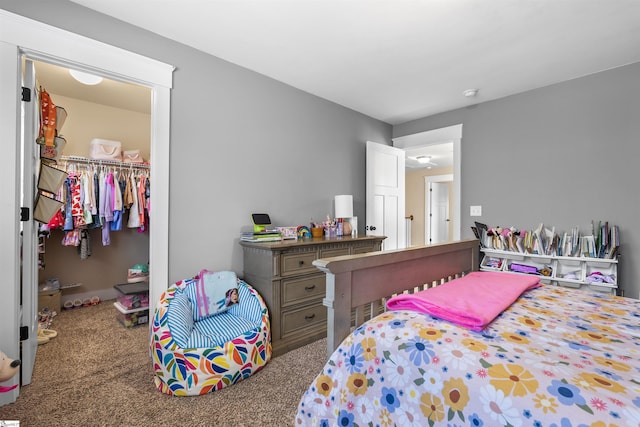 bedroom with a closet, a walk in closet, and carpet flooring