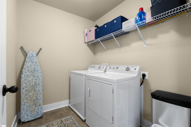 washroom featuring laundry area, tile patterned floors, washing machine and dryer, and baseboards