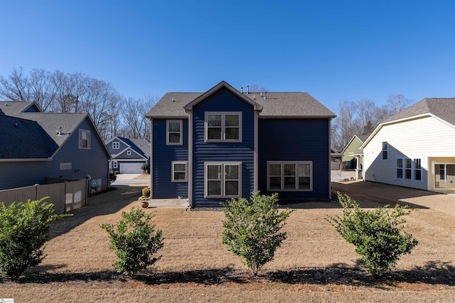 back of property with a garage and fence