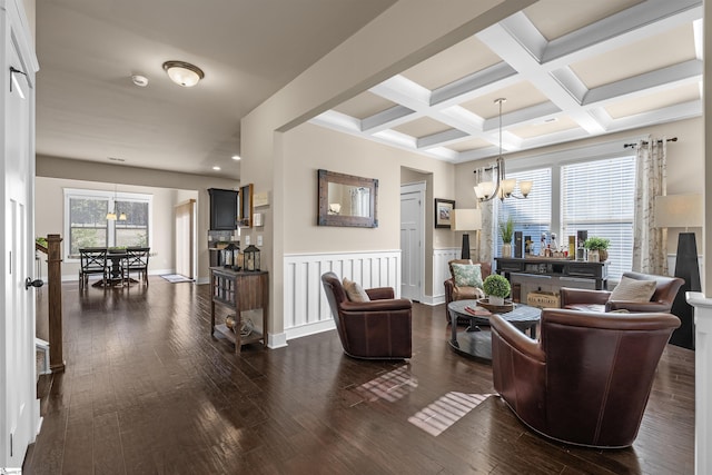 living room with dark wood-style floors, coffered ceiling, a notable chandelier, and beamed ceiling