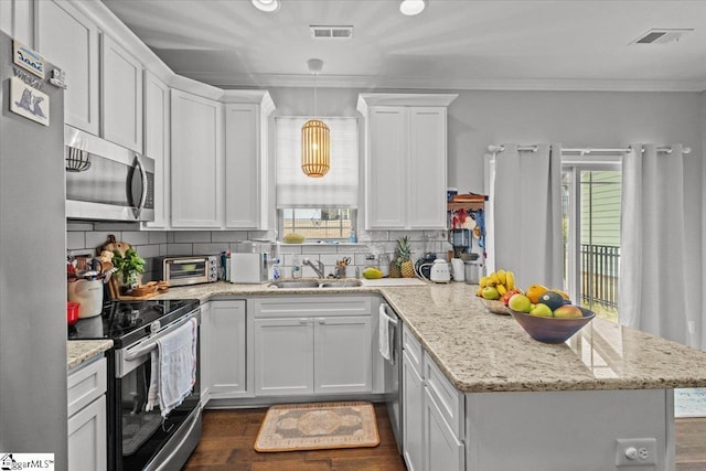 kitchen featuring visible vents, decorative backsplash, a peninsula, stainless steel appliances, and crown molding