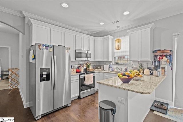 kitchen with arched walkways, stainless steel appliances, ornamental molding, white cabinetry, and a peninsula