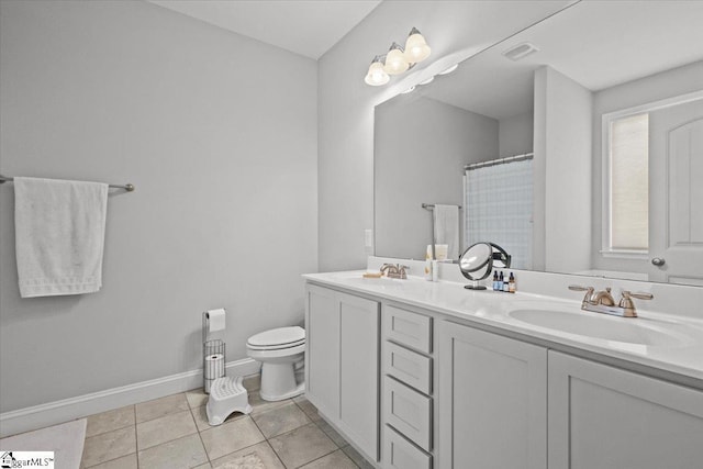 bathroom featuring tile patterned flooring, a sink, toilet, and double vanity