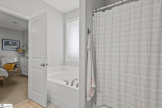 bathroom with a shower with curtain, crown molding, and a bath