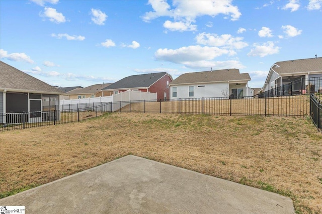 view of yard with a sunroom, a patio, a fenced backyard, and a residential view