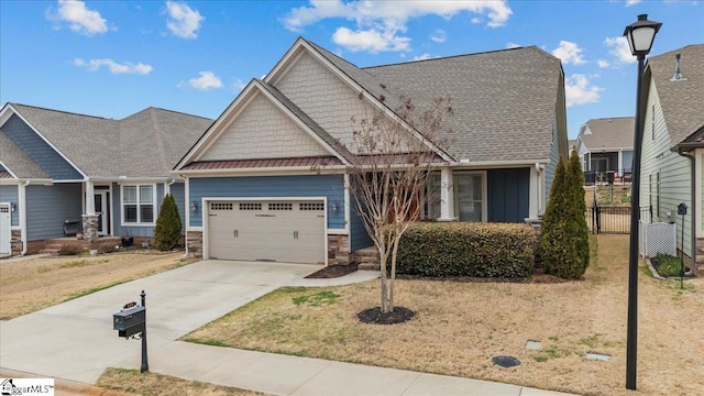 craftsman-style home with concrete driveway, metal roof, an attached garage, a standing seam roof, and fence