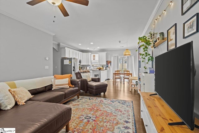 living room with ornamental molding, a ceiling fan, recessed lighting, and wood finished floors