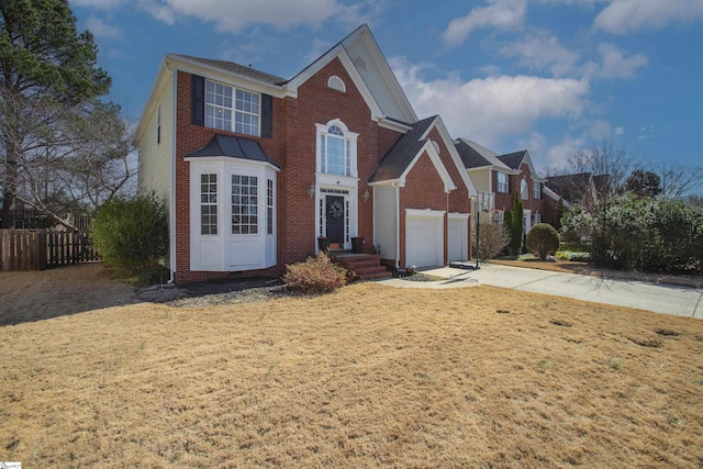 traditional home featuring driveway, a garage, brick siding, fence, and a front yard