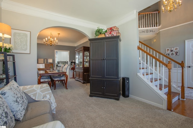 living area featuring arched walkways, carpet flooring, a notable chandelier, and stairs