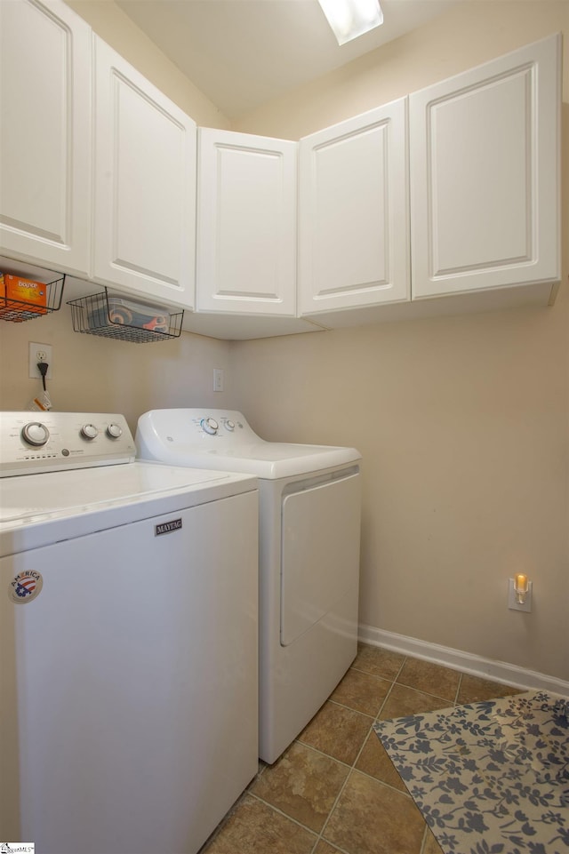 washroom with cabinet space, baseboards, washer and dryer, and tile patterned floors