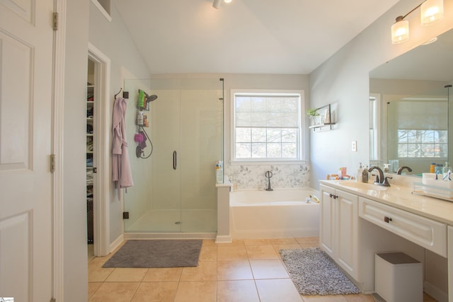 bathroom with tile patterned floors, a spacious closet, a stall shower, vanity, and a bath