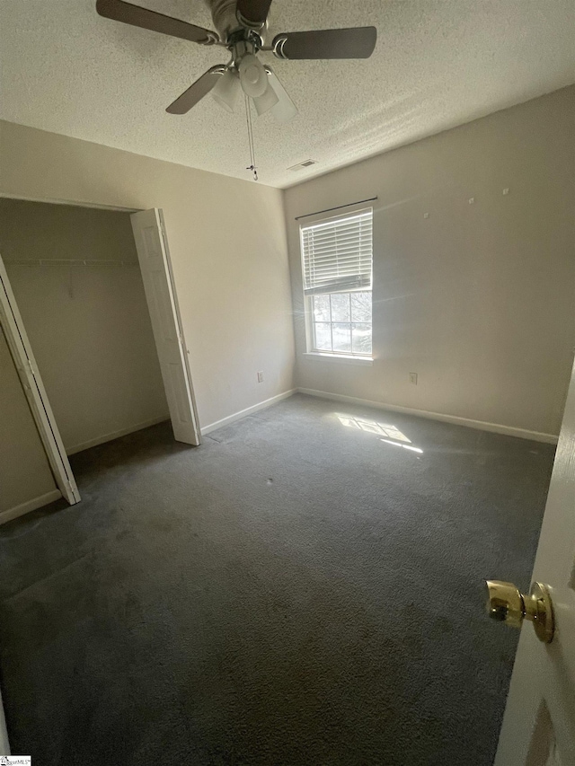 unfurnished bedroom featuring visible vents, baseboards, a ceiling fan, a textured ceiling, and carpet flooring